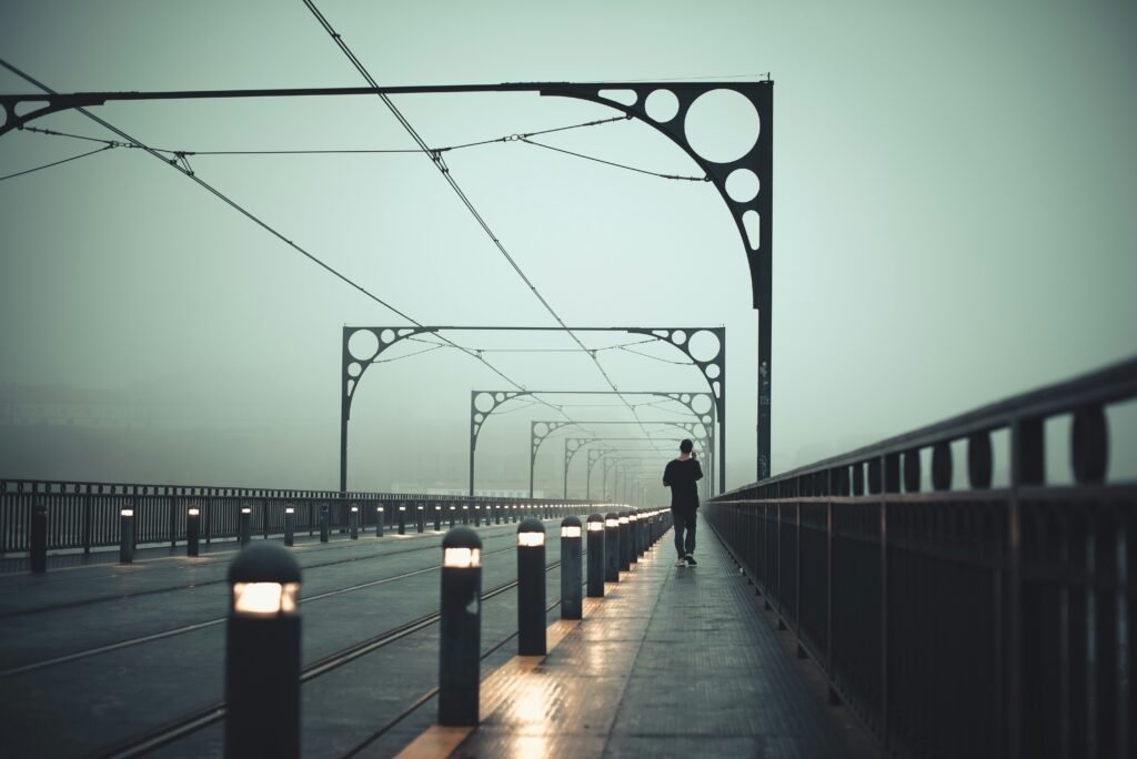 Lone figure walking over a bridge